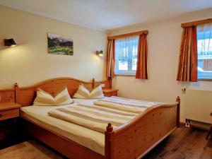 a bedroom with a large wooden bed with white pillows at Bergbauernhof Haug in Bad Hindelang