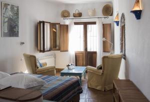 a bedroom with a bed and chairs and a table at Hotel Los Castaños in Cartajima
