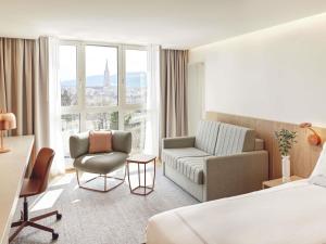 a hotel room with a bed and a chair at Swissôtel Kursaal Bern in Bern +83 photos