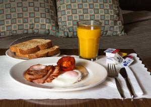 a plate of breakfast food and a glass of orange juice at Bankstown Motel 10 in Bankstown
