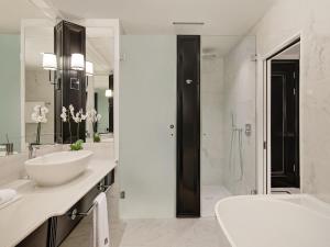 a white bathroom with a sink and a shower at Fairmont Windsor Park in Windsor