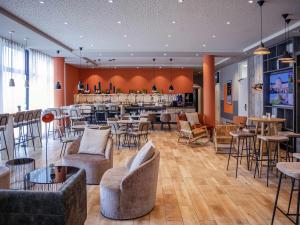a restaurant with tables and chairs and a bar at Adagio Access Stuttgart Airport Messe in Leinfelden-Echterdingen