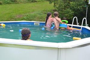 a group of people in a swimming pool at Résidence les Papaillons in Enney