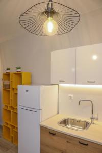 a kitchen with a white refrigerator and a ceiling fan at Cozy Twins - Terra in Kavála +17 photos