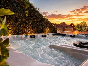 a jacuzzi tub in front of a wall at Les Arches d'Or - Loft 200 m2 avec Rooftop, Jacuzzi et 3 Suites - Centre 5 min - Proche A7-A9 in Orange