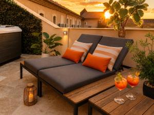 a bench on a patio with two glasses of wine at Les Arches d'Or - Loft 200 m2 avec Rooftop, Jacuzzi et 3 Suites - Centre 5 min - Proche A7-A9 in Orange