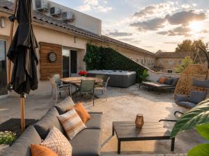 a patio with a couch and a table at Les Arches d'Or - Loft 200 m2 avec Rooftop, Jacuzzi et 3 Suites - Centre 5 min - Proche A7-A9 in Orange