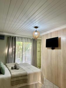 a bedroom with a bed and a flat screen tv at Guesthouse 52 in Groblersdal