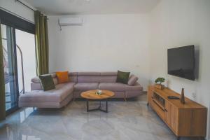 a living room with a couch and a tv at Vikanto Stay in Ulcinj