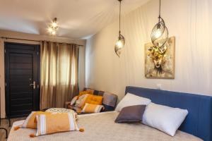 a bedroom with a blue bed and a chair at Cozy Twins - Terra in Kavála