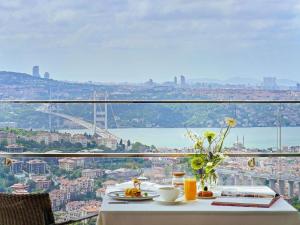 a table with food and a view of a city at Raffles Istanbul in Istanbul