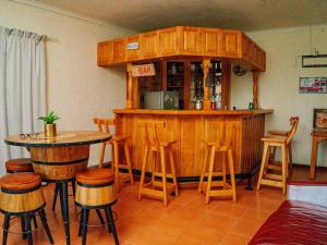 a kitchen with a bar with stools and a table at Emoyeni Guest House in Nelspruit