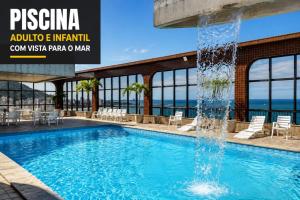 a swimming pool with a water fountain at Flat Pasárgada 404 in Vila Velha