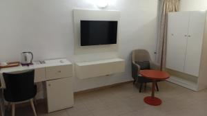 a bathroom with a sink and a tv on the wall at D'Mayor Suites, Gwarinpa in Gwarinpa +2 photos