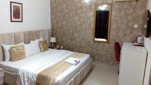 a hotel room with a bed and a mirror at D'Mayor Suites, Gwarinpa in Gwarinpa