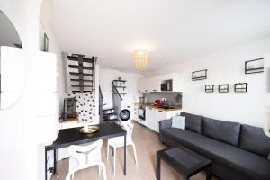 a living room with a couch and a table at L'évasion - duplex in Zillisheim