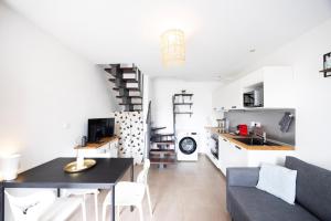 a living room with a couch and a table at L'évasion - duplex in Zillisheim