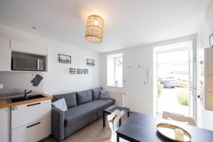 a living room with a couch and a table at L'évasion - duplex in Zillisheim +12 photos