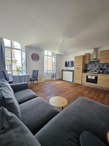 a living room with a couch and a kitchen at Church View Apartments in Châteauneuf-Val-de-Bargis