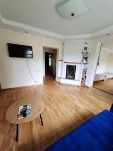 a living room with a blue couch and a table at Cozy Garden Villa in Ventspils