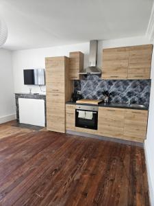 a kitchen with wooden cabinets and wooden floors at Church View Apartments in Châteauneuf-Val-de-Bargis +5 photos