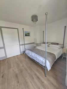 a bedroom with a bed in a room with wooden floors at Church View Apartments in Châteauneuf-Val-de-Bargis