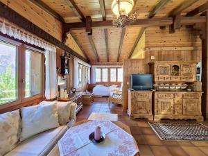 a living room with a couch and a tv at Chalet Himmulriich by Interhome in Gasenried