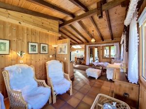 a living room with wooden walls and chairs at Chalet Himmulriich by Interhome in Gasenried +33 photos