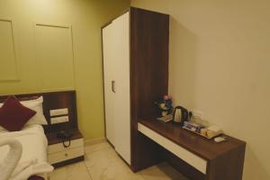 a hotel room with a bed and a night stand at Hotel Ayodhya Inn in Lokāpur +11 photos