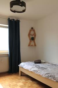 a bedroom with a bed and a black curtain at Heimathafen Heilbronn in Heilbronn