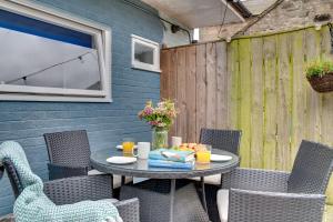 a patio with a table and chairs and a fence at The Hides in Seahouses