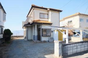 a white house with a driveway in front of it at Villa Vino in Fuefuki