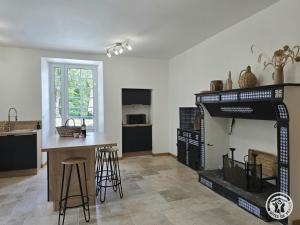 a kitchen and living room with a fireplace and a table at Chadalou in Savignac-les-Églises