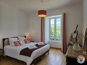 a bedroom with a large bed and a window at Chadalou in Savignac-les-Églises +24 photos