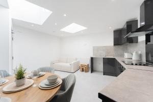 a kitchen and dining room with a wooden table at 4 Bedroom modern apartment in Birkenhead