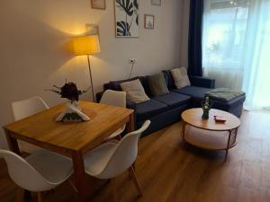 a living room with a blue couch and a table at Ferienwohnung Luitpold 1 in Memmingen