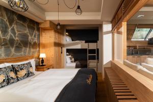 a bedroom with a large bed with a stone wall at Villa Miodula in Kościelisko