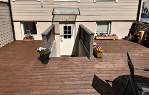 a deck with a white door and flowers on it at Free parking Apartment is located on a semi basement floor, with a warm floor in Ålesund +3 photos