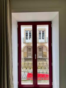 a red door in a room with a window at Apartamentos Fonte Velha in Ponte da Barca