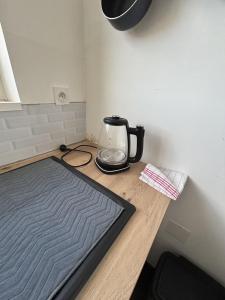 a tea kettle sitting on a wooden counter top at Le T3 Malpeaux – Arras Centre in Arras +5 photos