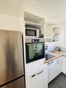 a kitchen with a refrigerator and a microwave at Le T3 Malpeaux – Arras Centre in Arras