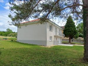 a white house with a large garage in a yard at VILLE au VERT in Verdun-sur-Meuse