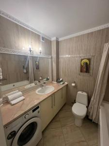 a bathroom with a sink and a washing machine at Classic Contemporary Apartament in Chişinău