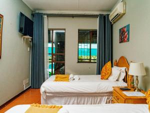 a hotel room with two beds and a window at Emoyeni Guest House in Nelspruit