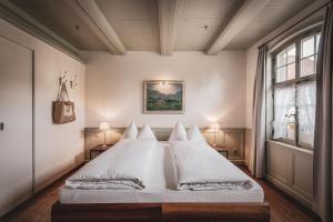 a bedroom with a bed with white sheets and a window at Hotel Kreuz in Dürrenroth