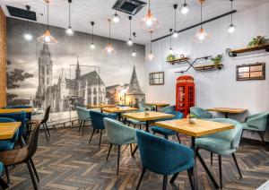 a restaurant with tables and chairs and a mural of a church at Hotel Memories OldTown in Budapest