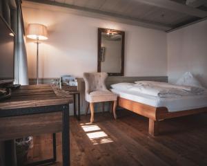 a bedroom with a bed and a chair and a mirror at Hotel Kreuz in Dürrenroth