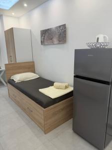 a bed in a room with a refrigerator at Apartmani Filip in Podaca