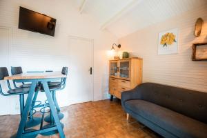 a living room with a couch and a table at Domaine de Guillaume Chalet 4 Pers in Auquainville