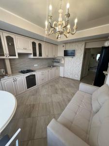 a large living room with a couch and a chandelier at Classic Contemporary Apartament in Chişinău